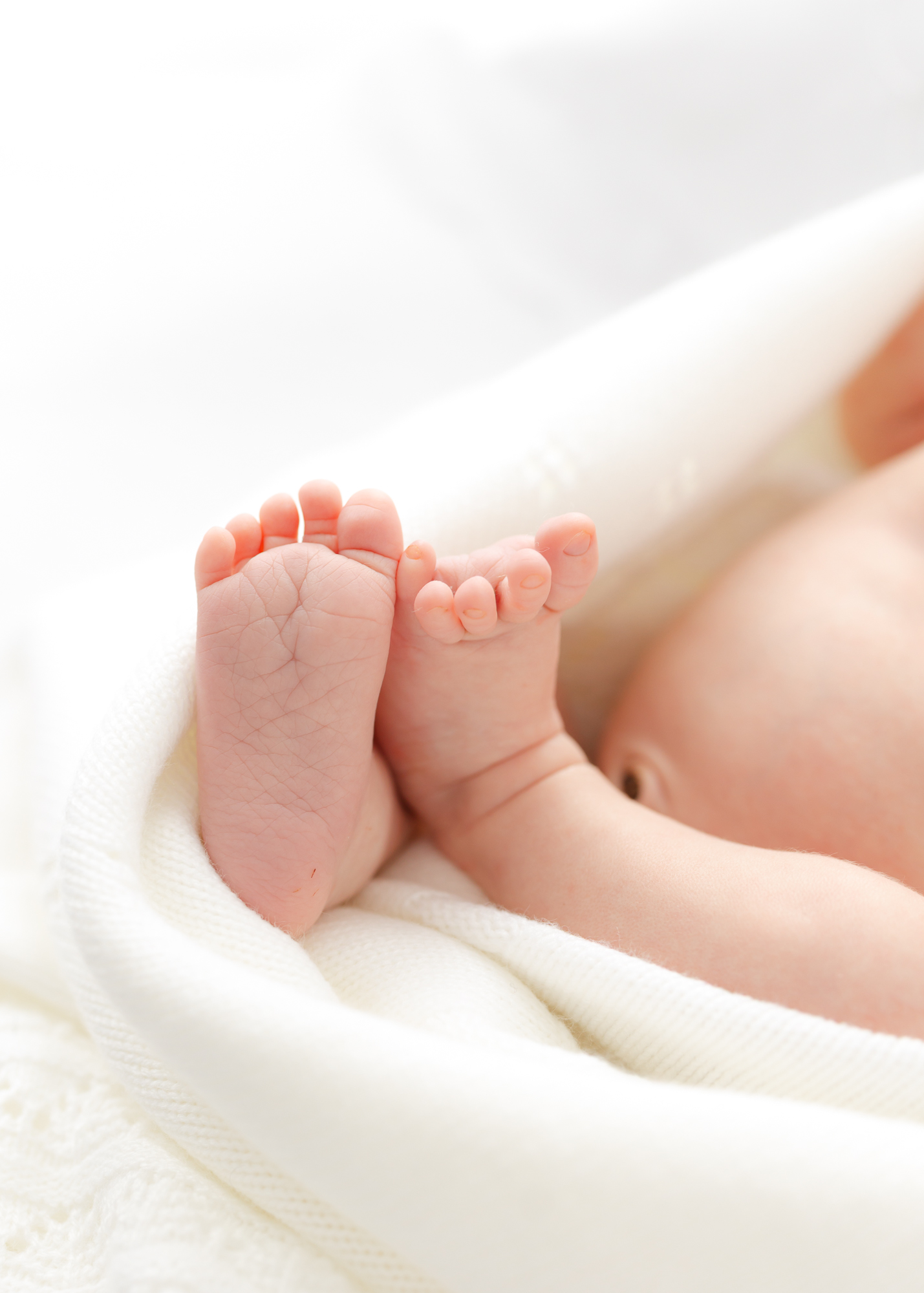 Little newborn toes showing from a white wrap