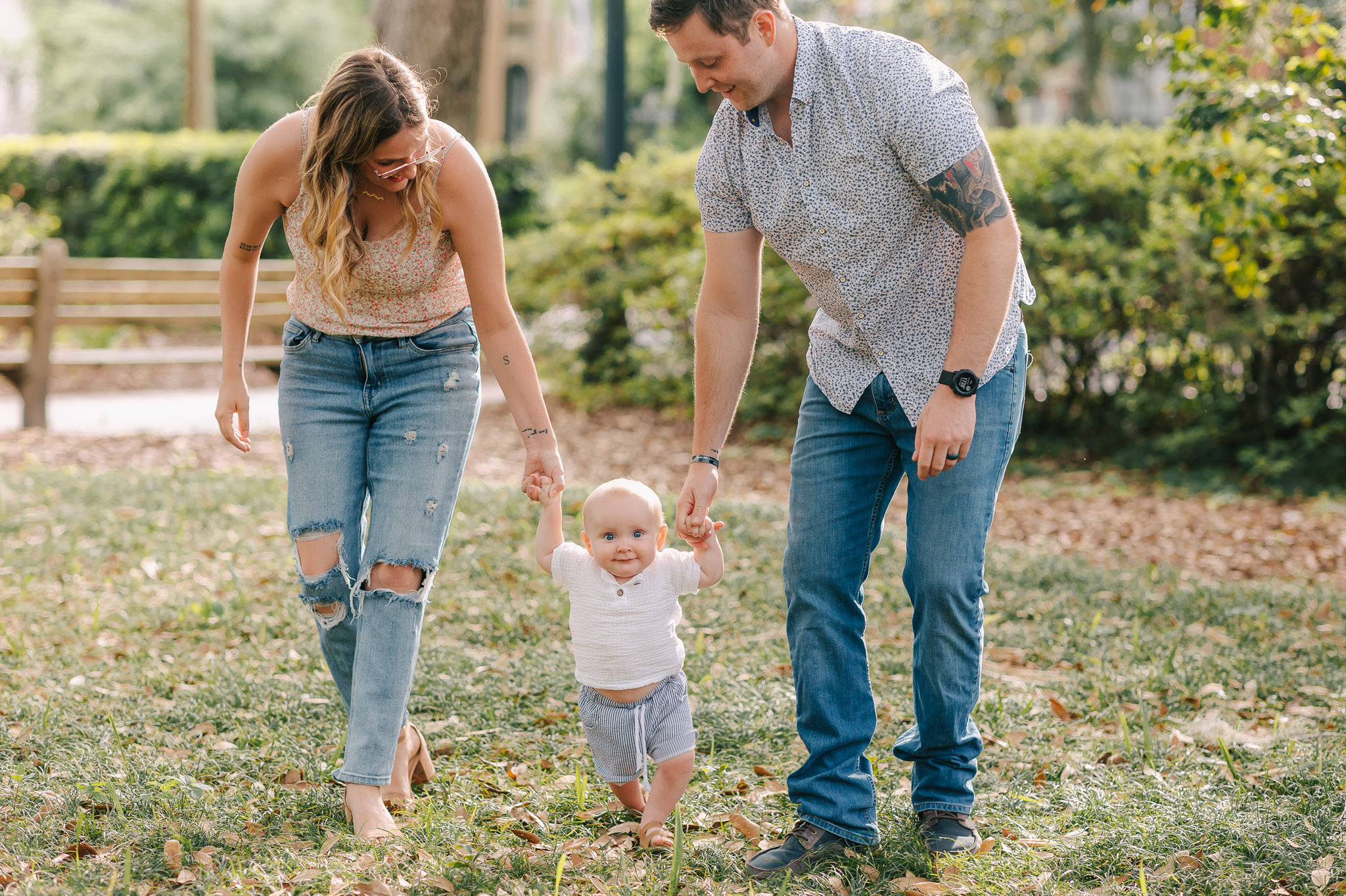 Young family holding toddlers hands while he tries to walk in Savannah, ga Things to do in Savannah ga with kids