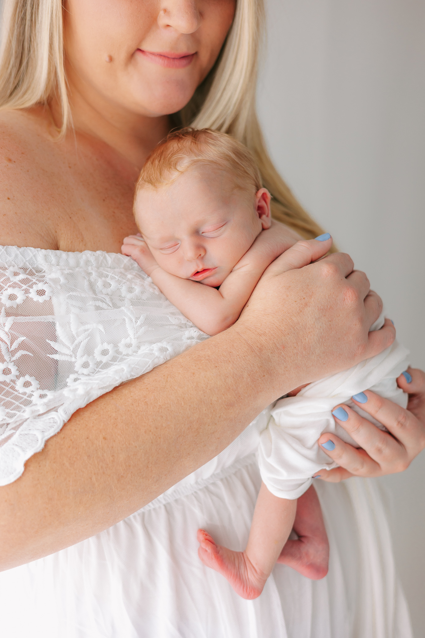 A newborn baby sleeps on mom's chest while she wears a white dress Wonderfully Made 4D Ultrasound