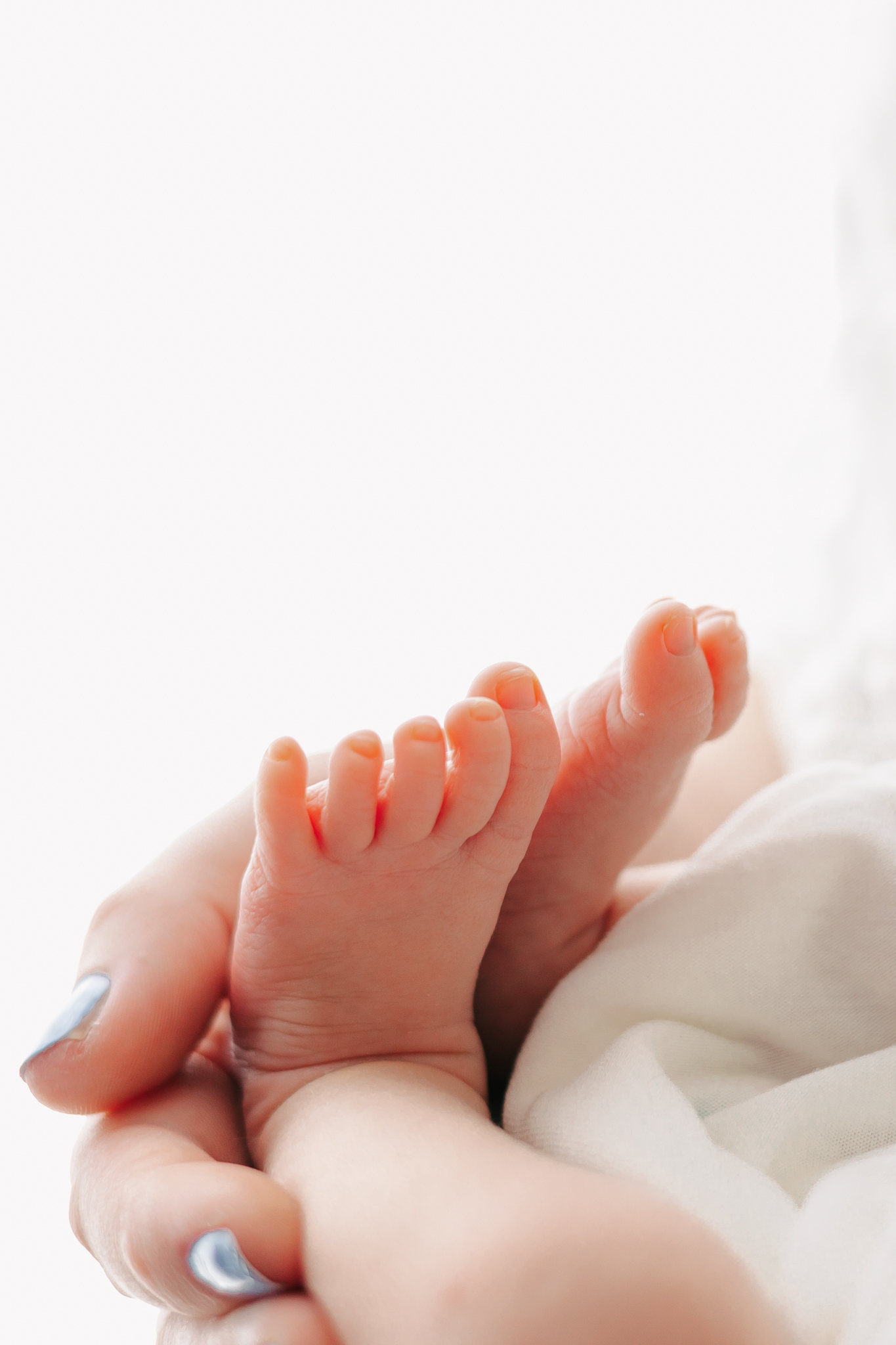 Details of a mother's hand holding her newborn baby's feet Wonderfully Made 4D Ultrasound