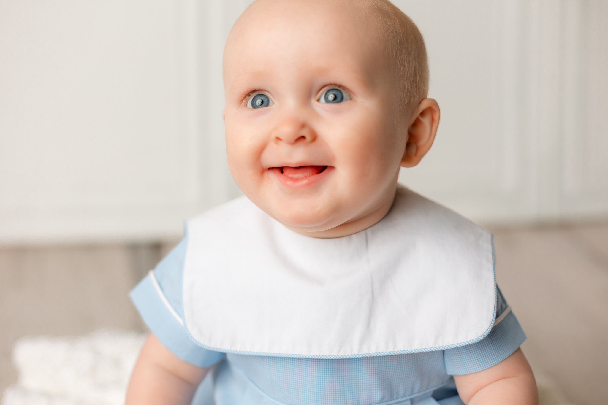 A young baby sits in a blue outfit on a studio floor peaches savannah ga