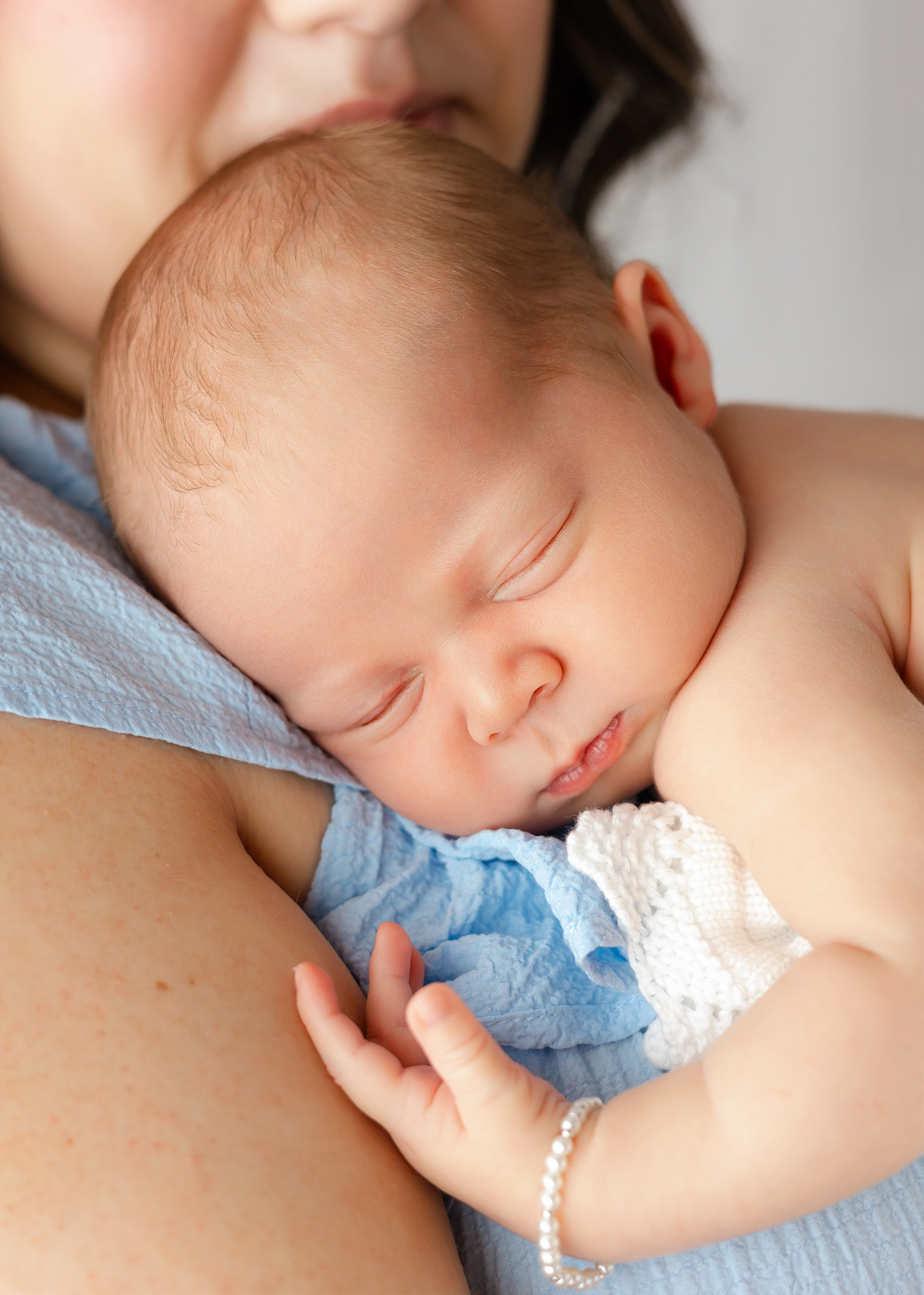 A newborn baby sleeps on mom's shoulder after meeting Georgia's Dream Nannies