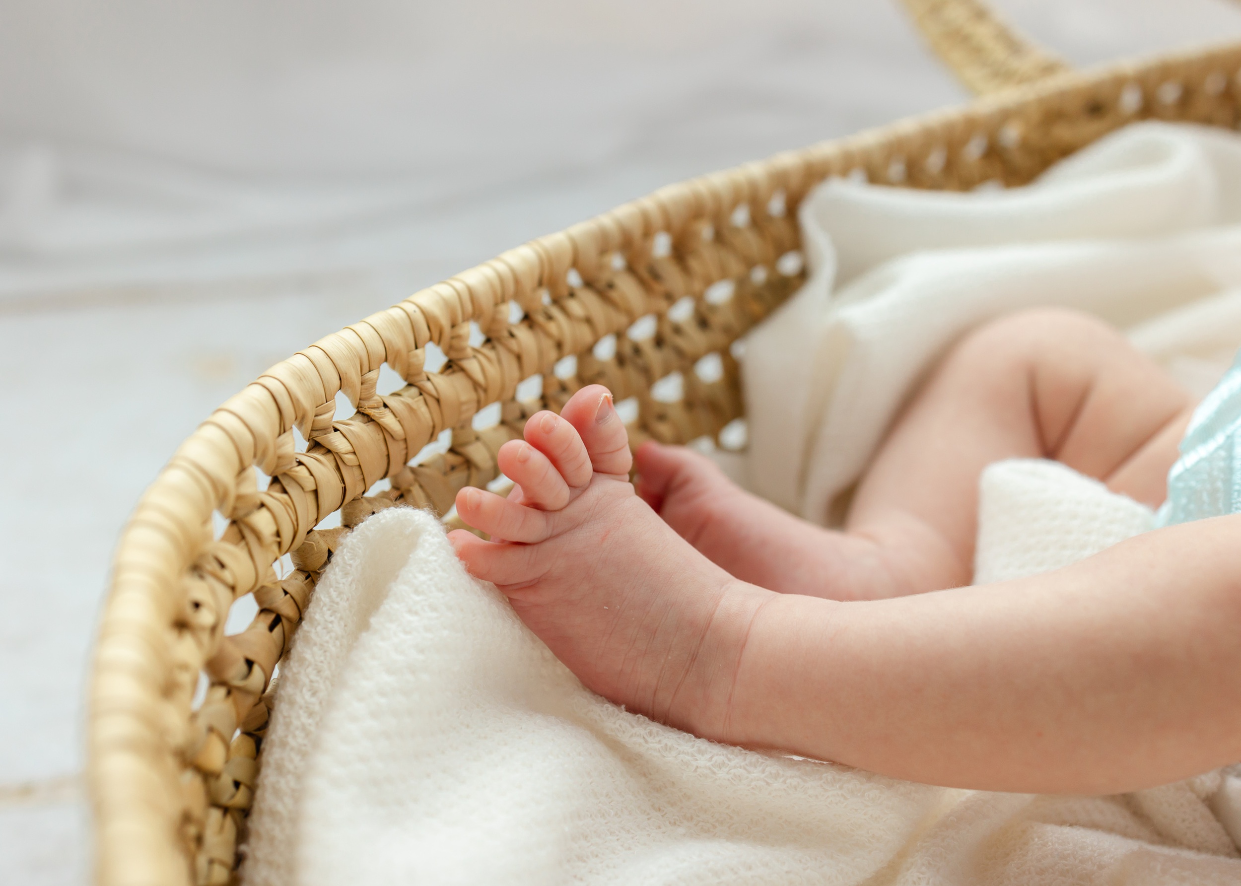 Details of a newborn's foot with stretched toes in a woven basket healthy thanks to wonderfully made ultrasound