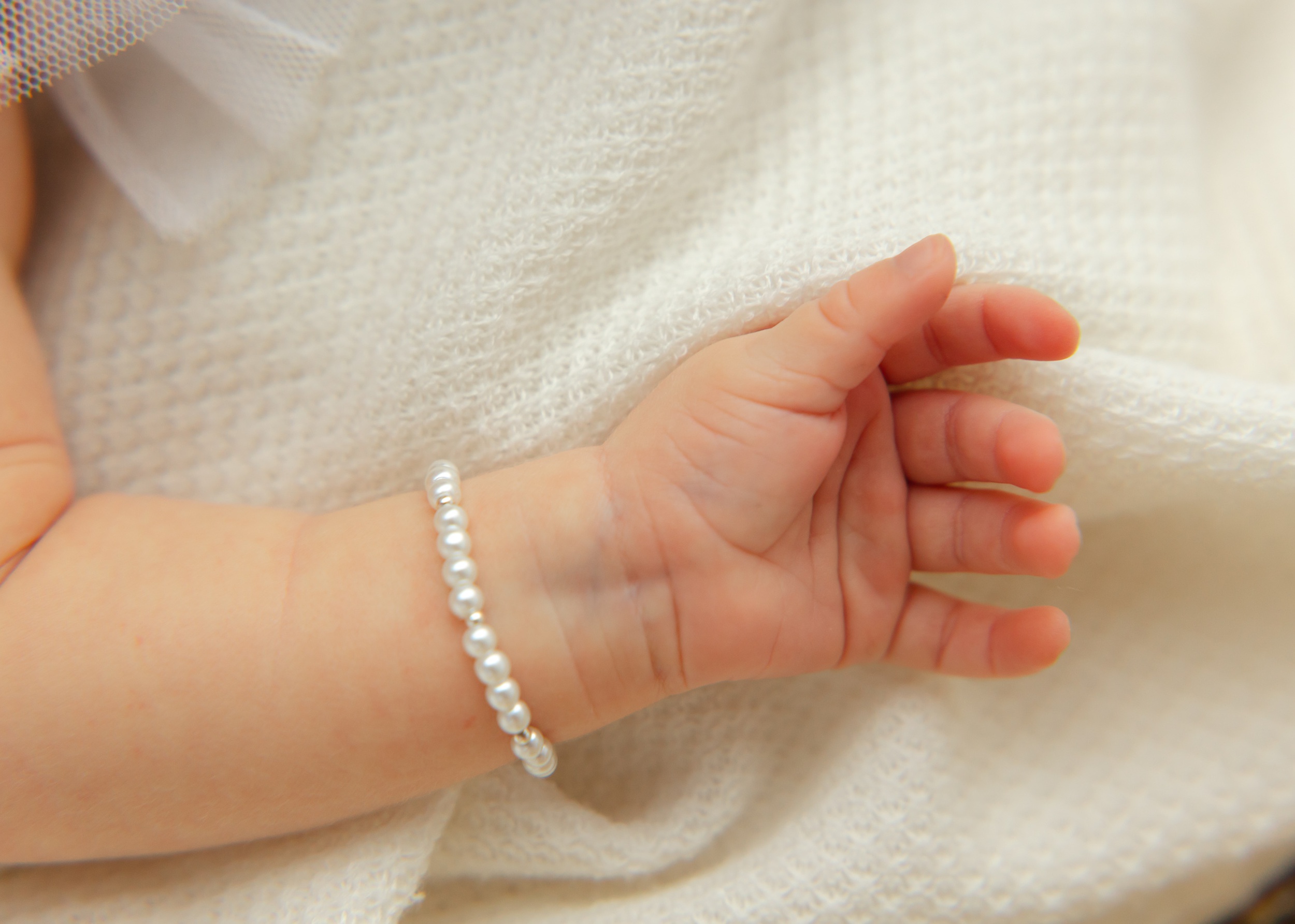 Details of a baby's arms with a pearl bracelet after using wonderfully made ultrasound