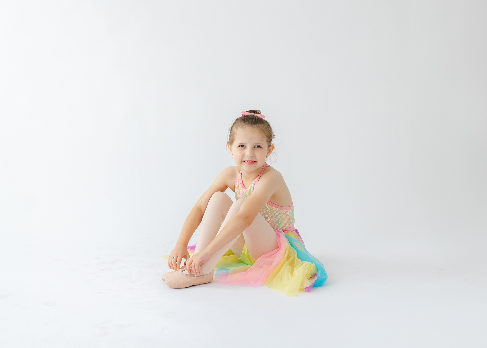 little dancer in a rainbow dance outfit with ballet shoes
