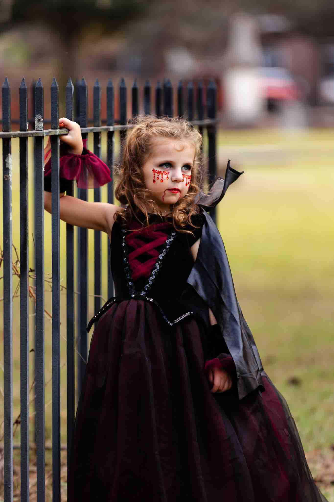 Little girl wearing a vampire costume posing in the colonial cemetery in Savannah, ga 