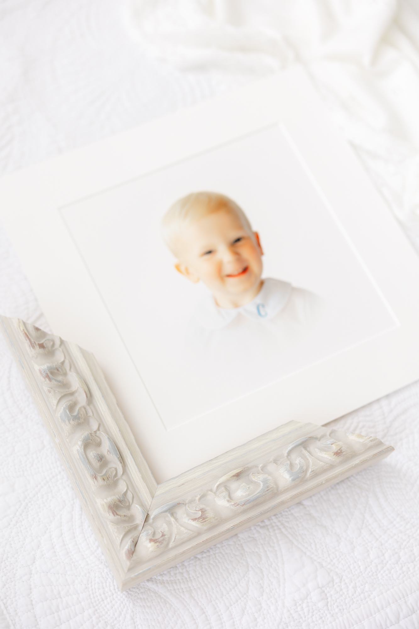 Heirloom portrait of a little boy smiling at the camera wearing a white Peter pan collared shirt