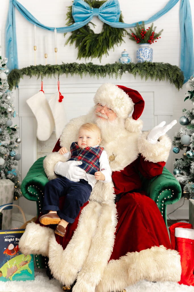 Young boy sitting with Santa during a professional Christmas portrait session in Savannah, Georgia.