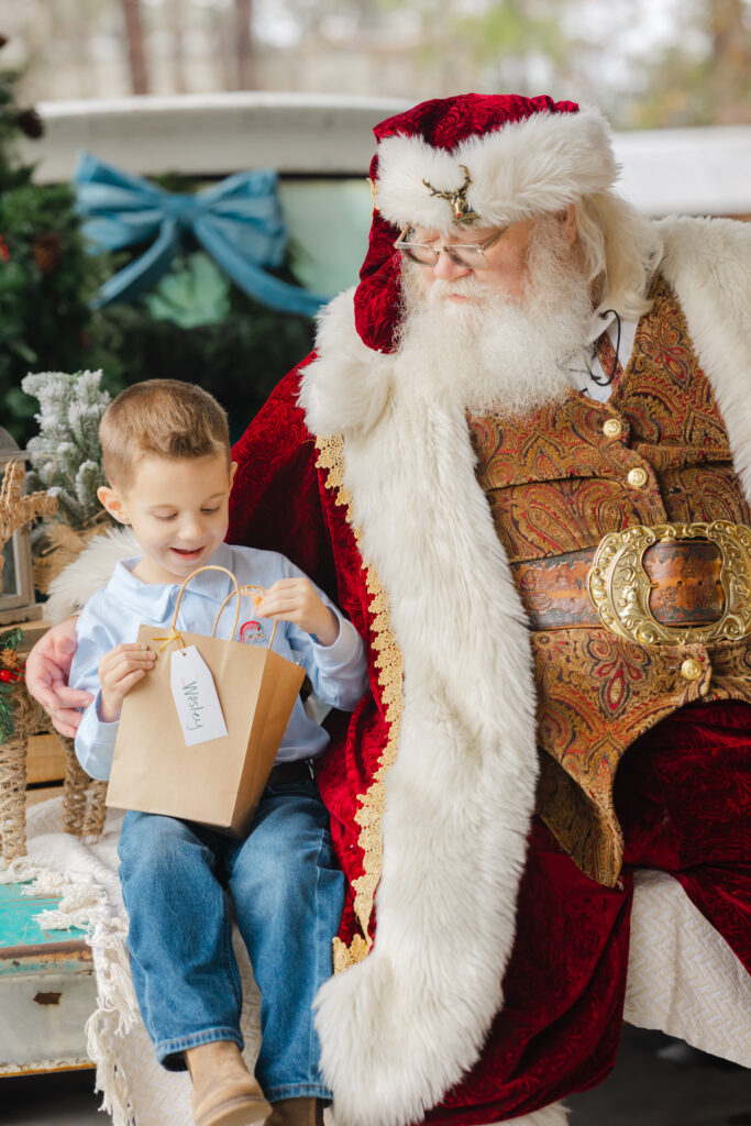 Child opening a special gift from Santa during a Christmas portrait session.