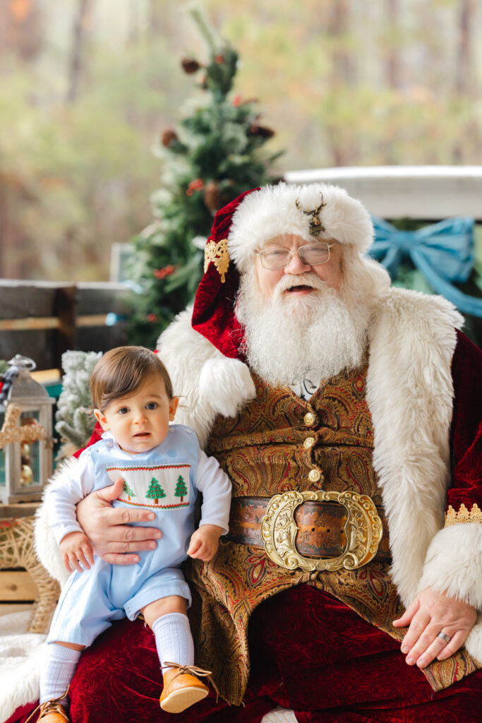 Baby sitting with Santa and looking at the camera during Santa photos in Savannah, GA.