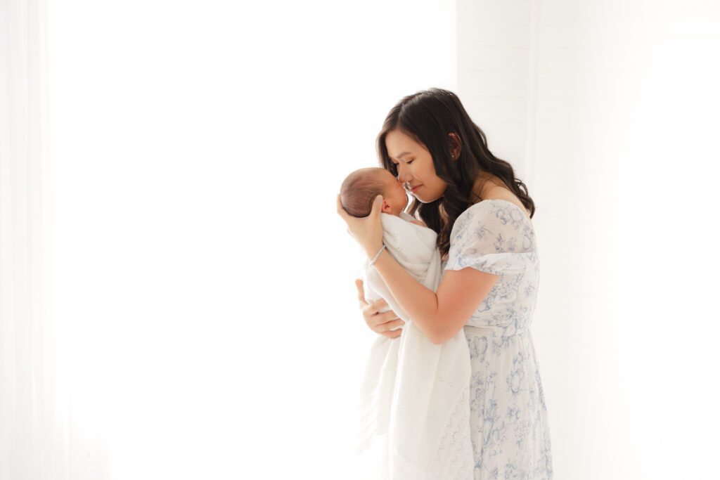 Newborn photography outfit inspiration featuring soft blue and white clothing for Mom and baby.