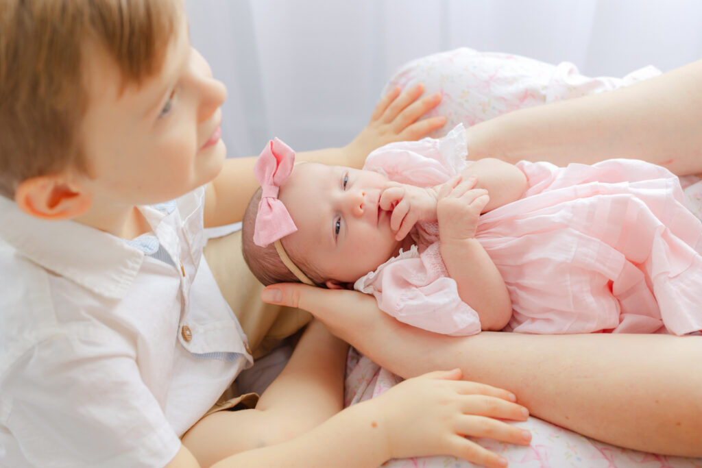 Newborn baby girl with her toddler big brother during a sibling newborn photography session in Savannah GA.