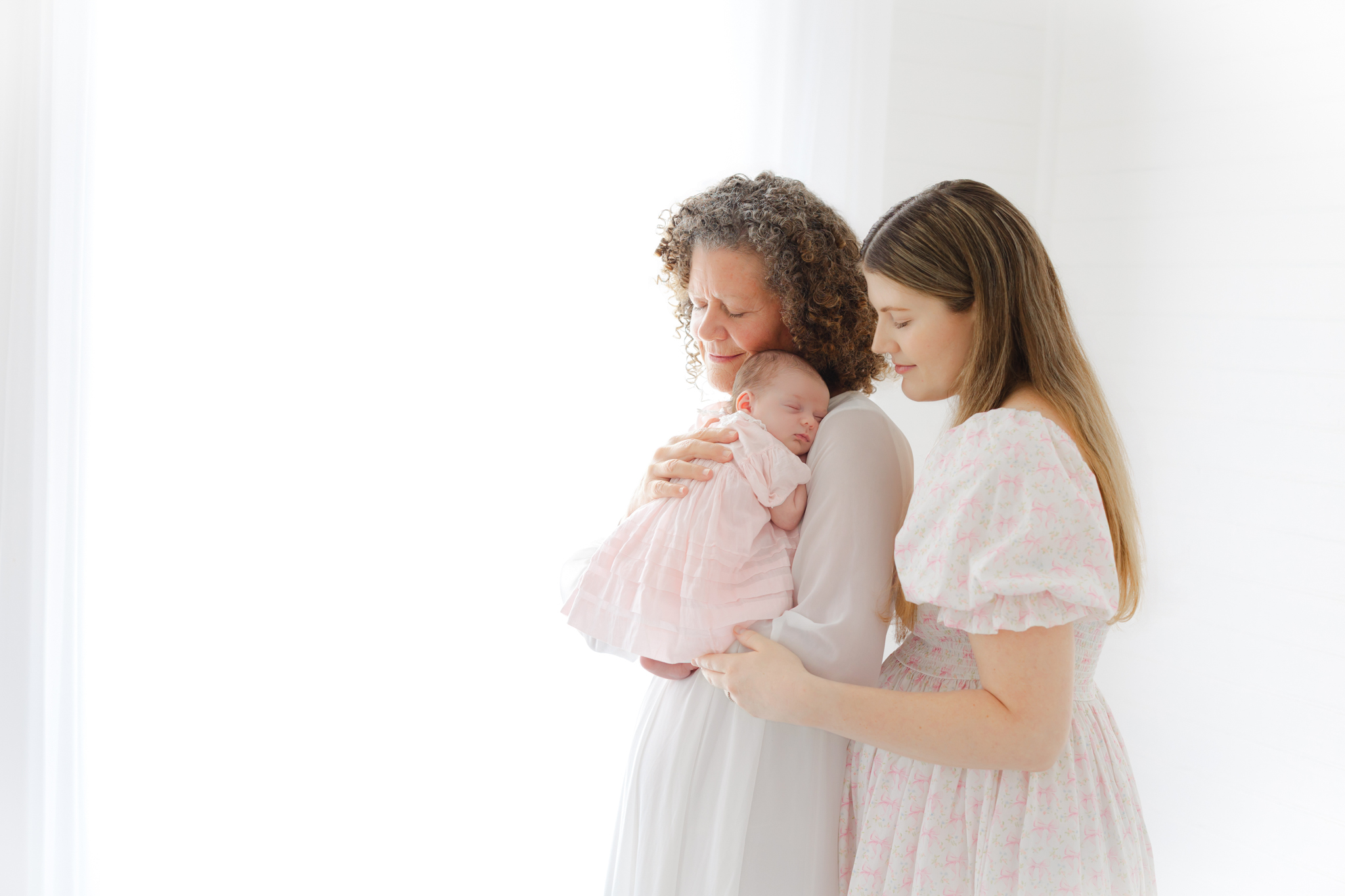 three generations, newborn, mom, and grandmother snuggling baby girl in a studio in Springfield, ga