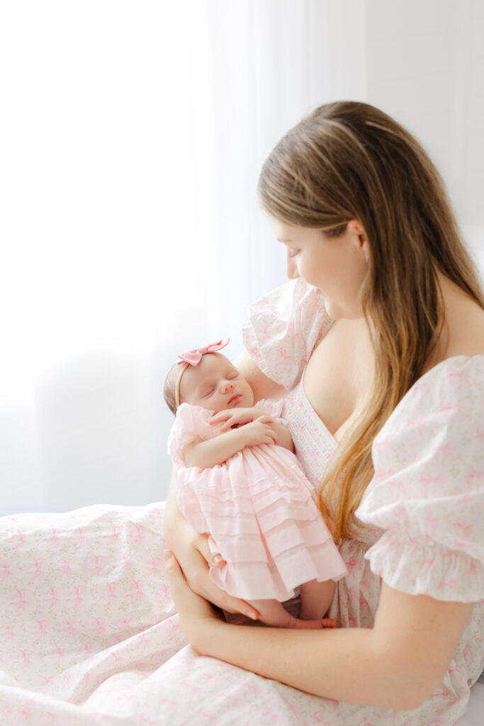 Mom holding her baby girl during a Savannah newborn photography session in a light filled studio.