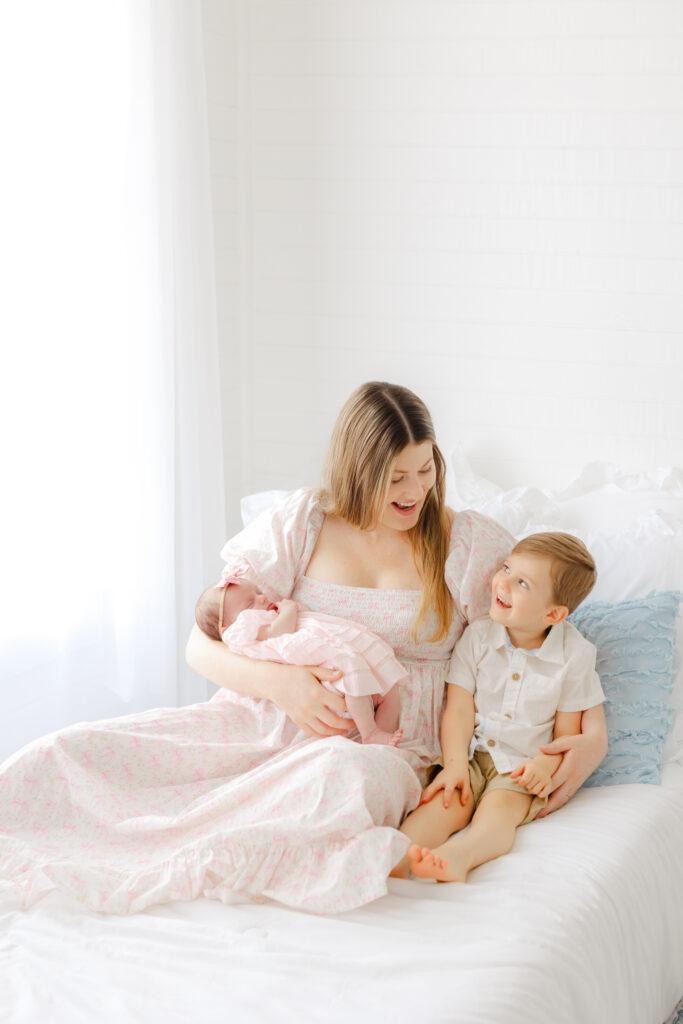 Newborn photos with a toddler sibling featuring mom, baby girl, and big brother together in a Savannah studio.