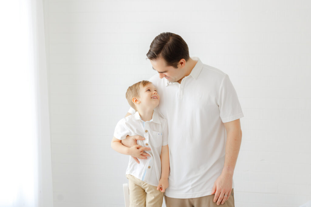 Dad sharing a playful moment with his three year old son during a Savannah studio newborn session.